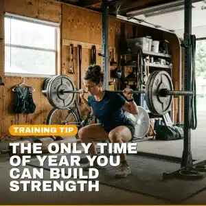 Runner doing a heavy barbell squat in a garage gym, strength training between races